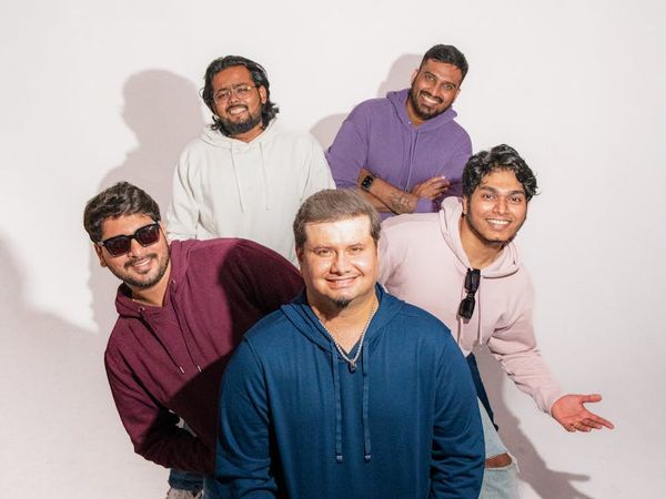 A diverse group of people smiling in a bright, modern studio.
